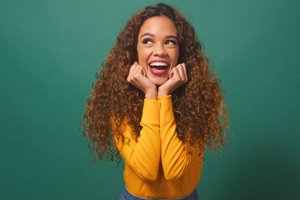 Krásná multietnická žena se usmívá a směje, ruce pod bradou, studio. Kvalitní fotografie - Fotografie, Obrázek