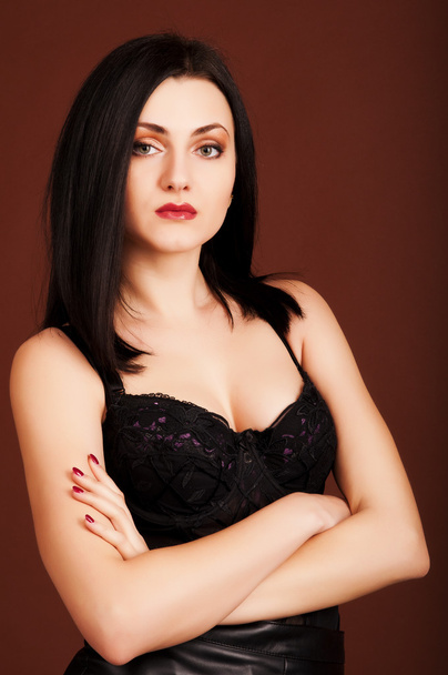 Brunette woman in black dress on the brown background - Foto, immagini
