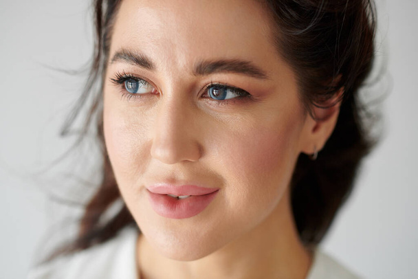 Tvář mladé ženy s hlubokýma modrýma očima odvracející se - Fotografie, Obrázek