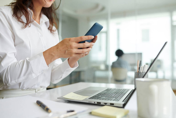 Cropped image of businesswoman checking notifications on smartphone - Photo, Image