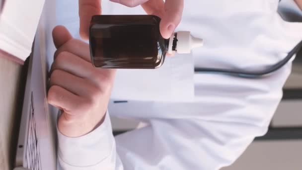 Ο γιατρός προσφέρει ένα σωλήνα του φαρμάκου μέσω της online επικοινωνίας. Ηλεκτρονική ιατρική γνωμάτευση. Κάθετη βίντεο - Πλάνα, βίντεο