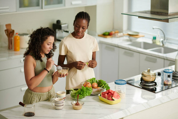 Junge Frauen essen Haferflocken und frisches Obst und Gemüse zum Frühstück - Foto, Bild
