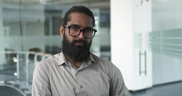 Este retrato captura a un empresario indio vistiendo un par de gafas y mostrando una cálida sonrisa. Su expresión amistosa emana confianza y accesibilidad. - Metraje, vídeo