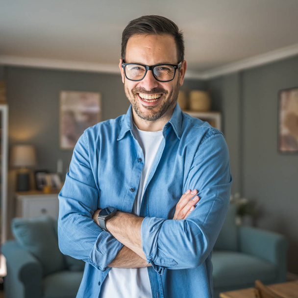 Egy férfi felnőtt portré fehér férfi szakállal és szemüveggel áll otthon boldog mosoly másolás hely - Fotó, kép