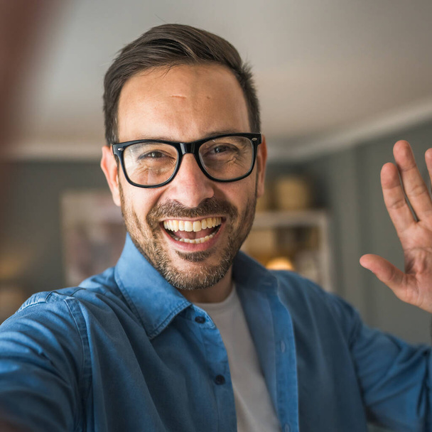 Yksi mies aikuinen muotokuva valkoihoinen mies parta ja silmälasit seistä kotona onnellinen hymy kopioi tilaa omakuva selfie - Valokuva, kuva