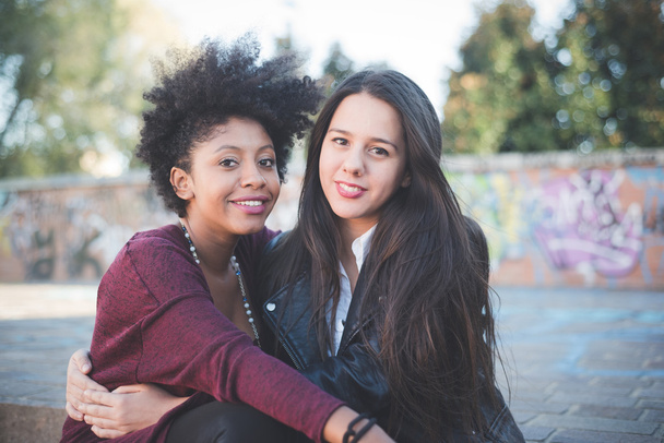Duas meninas multiétnicas na cidade
 - Foto, Imagem