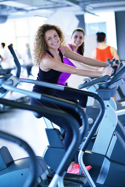 Two women working out at fitness cycle in modern sport  gym - Foto, imagen