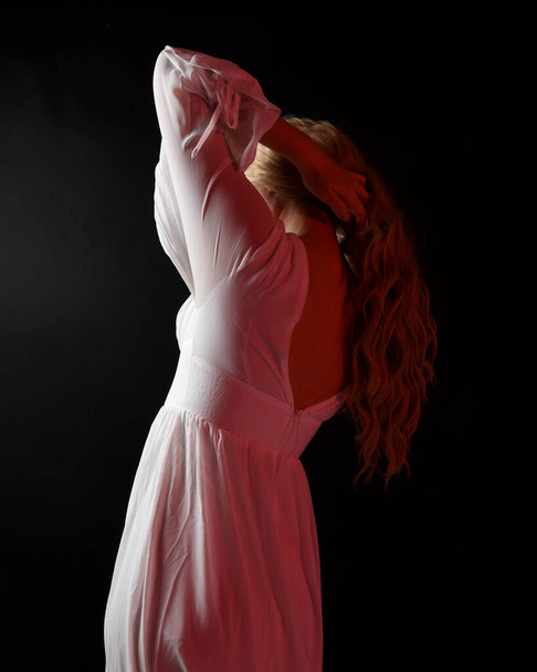 Close up retrato de noiva vampiro loira assustadora vestindo elegante vestido de fantasia halloween branco. Isolado no fundo do estúdio escuro com as mãos gestuais angustiadas estendendo a mão  - Foto, Imagem