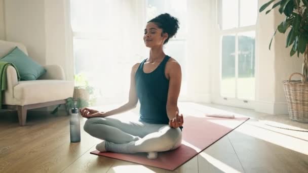 Vrouw, lotushouding en meditatie met yoga voor fitness thuis, mindfulness met zen, kalm en spiritueel. Ademhaling, rust en beweging in de woonkamer, gezondheid en welzijn voor genezing en zelfzorg. - Video