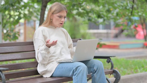 Mujer joven sorprendido por la pérdida en el ordenador portátil al aire libre - Foto, imagen