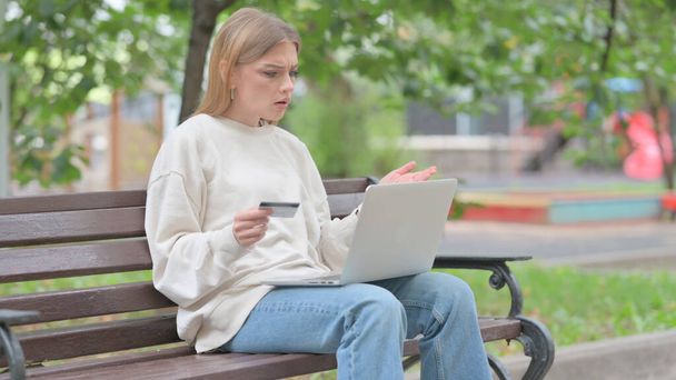 若い女性がラップトップの屋外でオンライン決済の失敗によって動揺 - 写真・画像