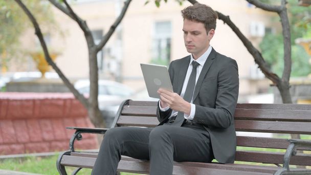 Businessman using Tablet while Sitting on Bench - Photo, Image