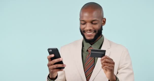 Happy businessman, credit card and phone in online shopping, banking or payment against a studio background. Black man with debit in wireless transaction, ecommerce or bank app on mobile smartphone. - Footage, Video