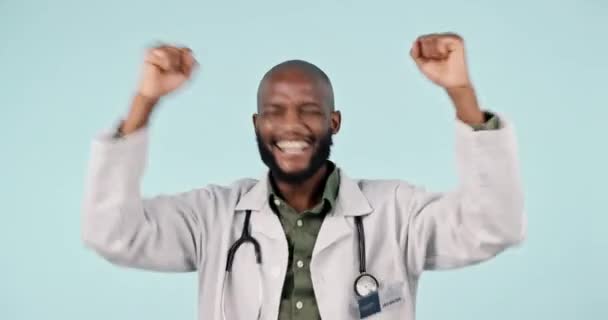 Celebration, fist pump and man doctor in a studio with success or achievement for good news. Happy, excited and young African male healthcare worker with job promotion isolated by white background - Footage, Video