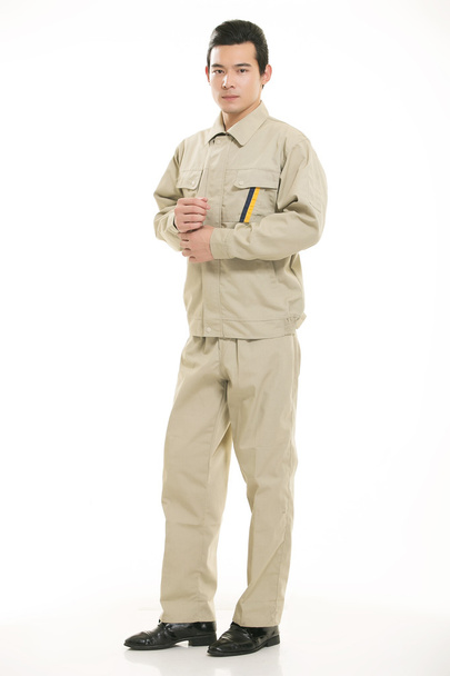 Молодой инженер различных профессий одежды стоя на белом фоне - Фото, изображение