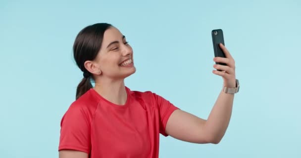 Peace, hands and selfie y woman in studio with kiss, gesture or emoji pose for profile picture on blue background. V, happy and female influencer smile for social media, blog or podcast post update. - Footage, Video