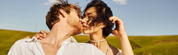matrimonio rustico, giovani sposi interrazziali che si baciano sul vento sotto il cielo blu in campo verde, banner - Foto, immagini