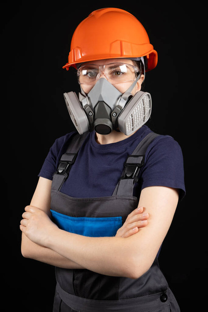 Žena v helmě, respirátoru a brýlích na černém pozadí. - Fotografie, Obrázek