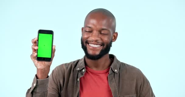 Ukazující, zelená obrazovka nebo šťastný černoch s mobilní slevou nebo prodej na logo prostoru. Reklama, úsměv nebo tvář africké osoby s mockup, novinky nebo propagace smartphone na modrém pozadí. - Záběry, video