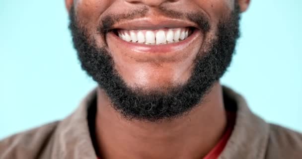 Dişler, yakın çekim ve stüdyoda gülümseyen siyah adam, mavi arka plan ya da diş, sağlık ve kozmetik için model. Afrikalı, dişçi ve ağız bakımında diş, hijyen ve gurur sahibi birinin yüzü.. - Video, Çekim