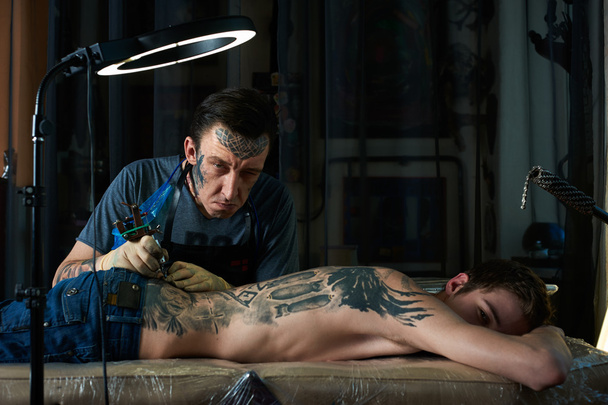 Tattoo artist makes faces - Foto, Imagen