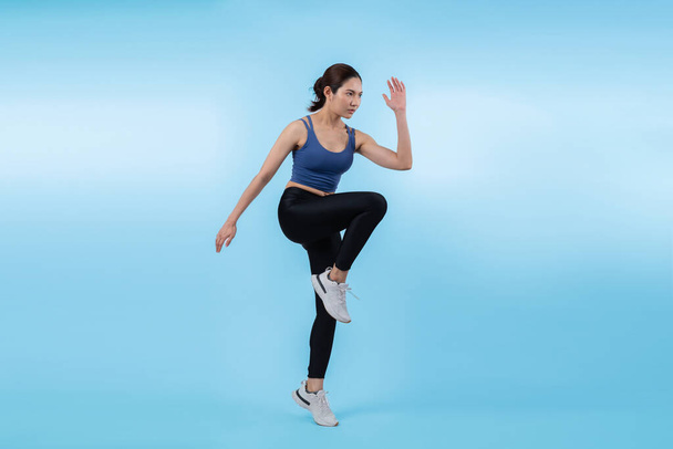 Side view fiatal sportos ázsiai nő futó testtartás stúdióban lövés elszigetelt háttérrel. Üldözi az egészséges fit test fizikum és kardio edzés testmozgás életmód koncepció. Élénk. - Fotó, kép