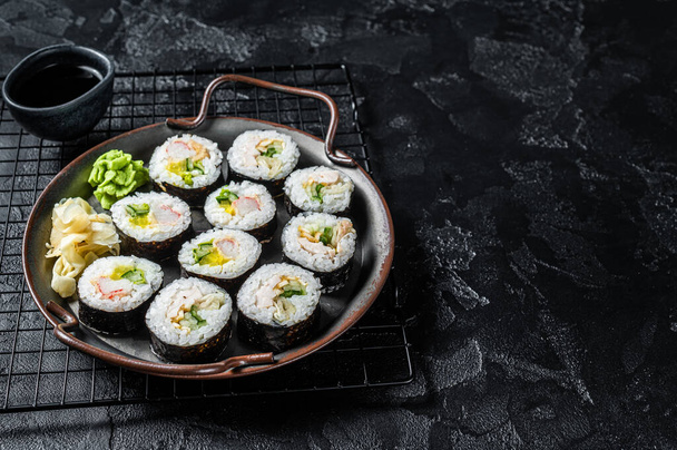 Kimbap gimbap lleno de verduras, huevo, anchoa y cangrejo, rollo de arroz coreano. Fondo negro. Vista superior. Copiar espacio. - Foto, imagen