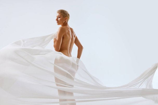 Портрет молодого голого жіночого тіла з прозорою плаваючою білою тканиною на грудях, стегнах і сідницях. Концепція природної краси тіла, здоров'я жінки, косметології. Реклама - Фото, зображення