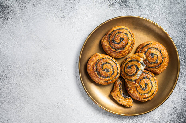 Poppy seed rolls and cardamom buns, Traditional Nordic baked sweet breads on wooden board. White background. Top view. Copy space. - Foto, afbeelding