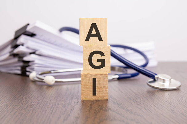 szöveg AGI írt fa blokkok közelében sztetoszkóp egy papír háttér, orvosi koncepció - Fotó, kép