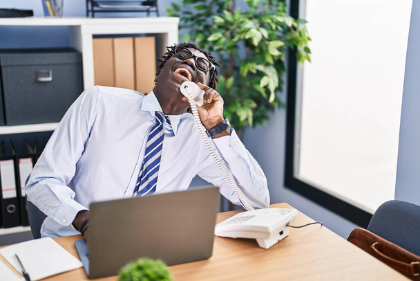 African american man business worker talking on telephone using laptop at office - Photo, image