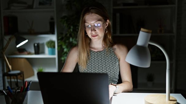 若い金髪の女性のビジネスワーカーはオフィスで働くノートパソコンを使用して - 写真・画像