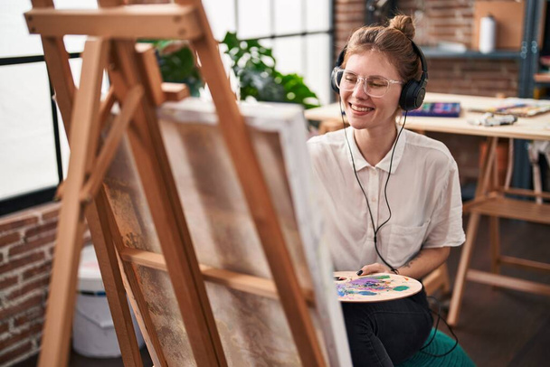 Jovem loira artista ouvindo música desenho no estúdio de arte - Foto, Imagem