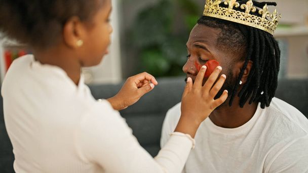 アフリカ系アメリカ人の父親と娘が王冠とバギーの目パッドを自宅で着用 - 写真・画像