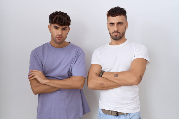 Homosexual gay couple standing over white background skeptic and nervous, disapproving expression on face with crossed arms. negative person.  - Photo, Image