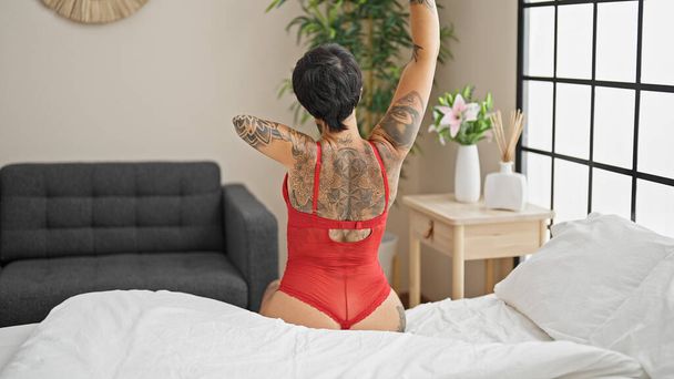 Latynoska kobieta z amputowanym ramieniem budzi się wyciągając ramię w sypialni - Zdjęcie, obraz