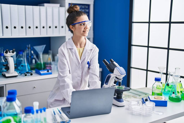 Imádnivaló lány tudós segítségével laptop dolgozik a laboratóriumban - Fotó, kép