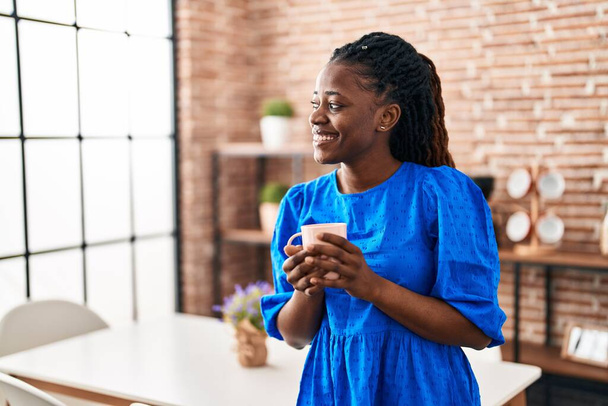 African american woman business worker smiling confident drinking coffee at home - Foto, afbeelding