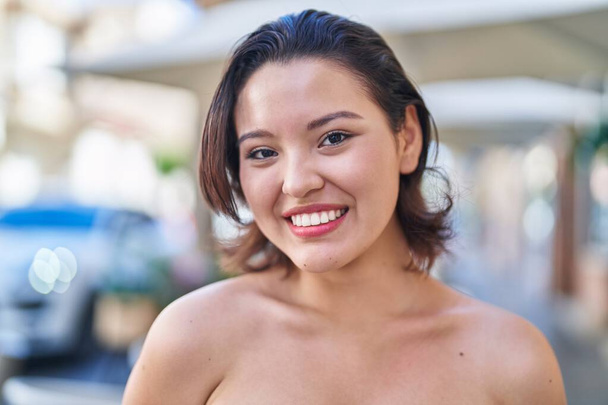 jonge latino vrouw glimlachen zelfverzekerd staan op straat - Foto, afbeelding