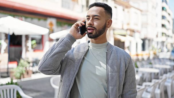 Giovane uomo ispanico che parla al telefono per strada - Foto, immagini