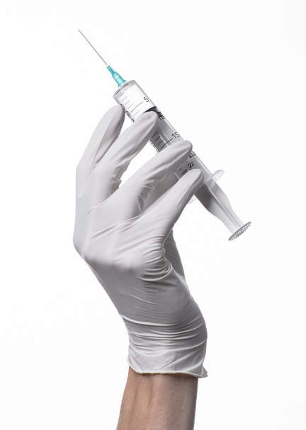 Doctor's hand holding a syringe, white-gloved hand, a large syringe, medical issue, the doctor makes an injection, white background, isolated, white gloves doctor - Foto, afbeelding