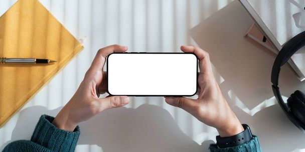 Woman holding blank screen mock up mobile phone. Mobile gadget concept. - Photo, Image