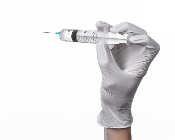 Doctor's hand holding a syringe, white-gloved hand, a large syringe, medical issue, the doctor makes an injection, white background, isolated, white gloves doctor - Foto, imagen