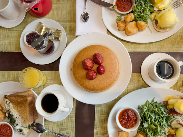 Kahvaltı, güzel manzara, krepli tipik Amerikan kahvaltı masası, yumurtalı Benedict, tost ve kahve. Güzel yemek ve içecek arka planı. Brunch masası konsepti  - Fotoğraf, Görsel