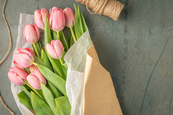 Rosa Tulpenblüten Strauß auf blauem Zementhintergrund. Flache Lage, Draufsicht. Frühlingskonzept. - Foto, Bild