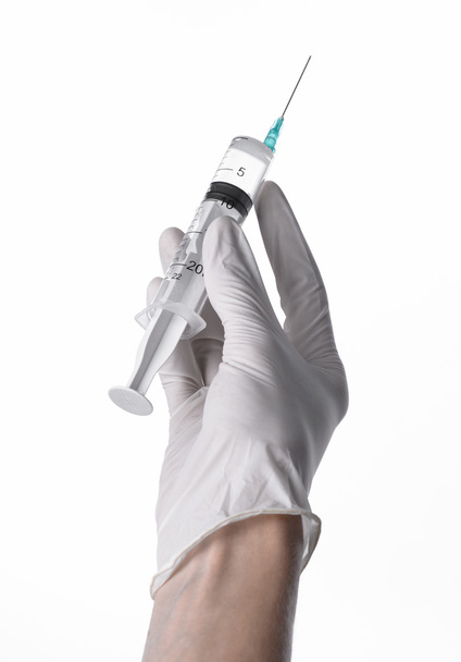 Doctor's hand met een injectiespuit, wit-gehandschoende hand, een grote spuit, medische kwestie, de arts maakt een injectie, witte achtergrond, geïsoleerd, witte handschoenen arts - Foto, afbeelding