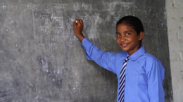Felice ragazza della scuola indiana in piedi di fronte a sfondo lavagna nera. Concetto educativo o Ritorno a scuola - Filmati, video