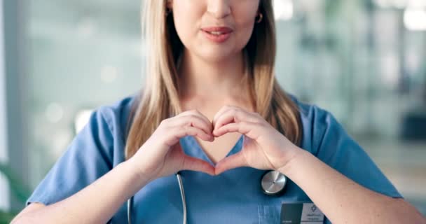 Handen, hart en gezondheid met een verpleegster in een ziekenhuis close-up voor liefde, medische ondersteuning of vertrouwen. Glimlach, gezondheidszorg en emoji met een gelukkige medicijnman in een kliniek voor deskundige cardiologie. - Video