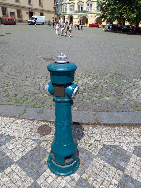 Poste de hidrante de hierro antiguo vintage en el fondo de la acera y la plaza del casco antiguo - Foto, Imagen
