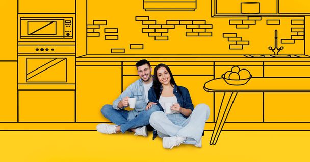 Smiling young european couple enjoy cups of coffee, dreams of own house, buy new home, in kitchen interior with drawn furniture, isolated on yellow studio background. Design room, moving - Foto, imagen